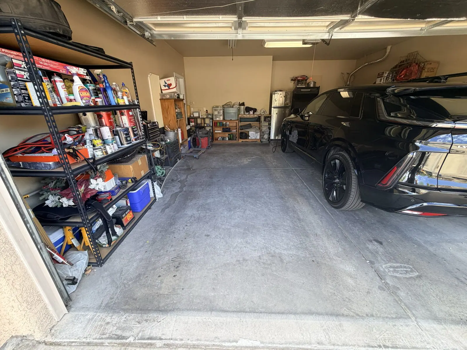 Same garage with the parking bay cleared and the shelving left in place after a garage cleanout by Henderson Junk Solutions