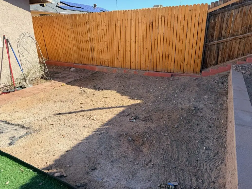 Same Downtown Henderson backyard corner cleared to bare dirt after construction debris removal by Henderson Junk Solutions