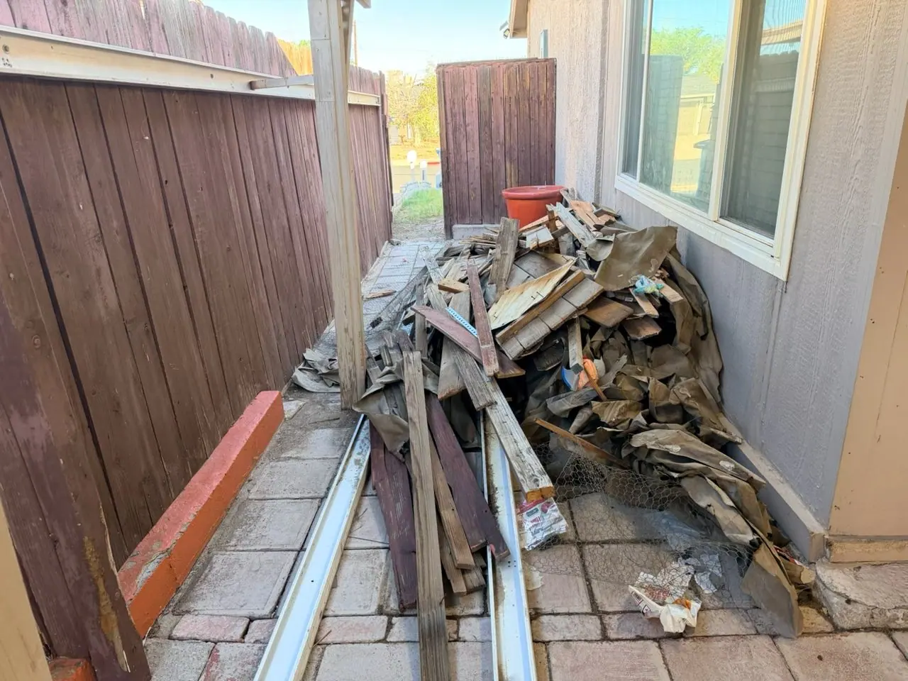 Old fence boards, posts and broken pickets piled along a Downtown Henderson side yard after a fence rebuild