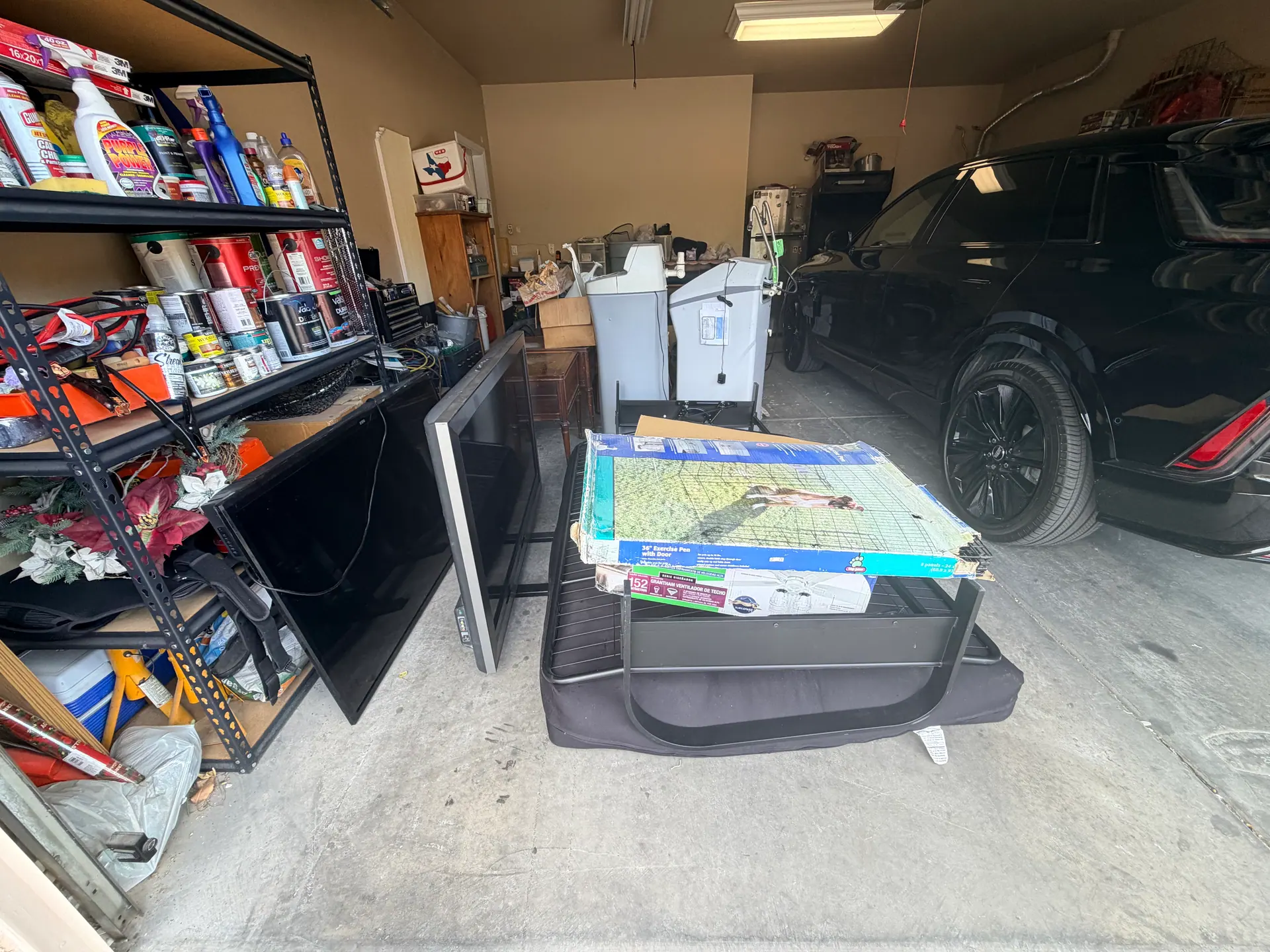 McCullough Hills garage filled with old water softeners, furniture, broken TV, and rolled carpet